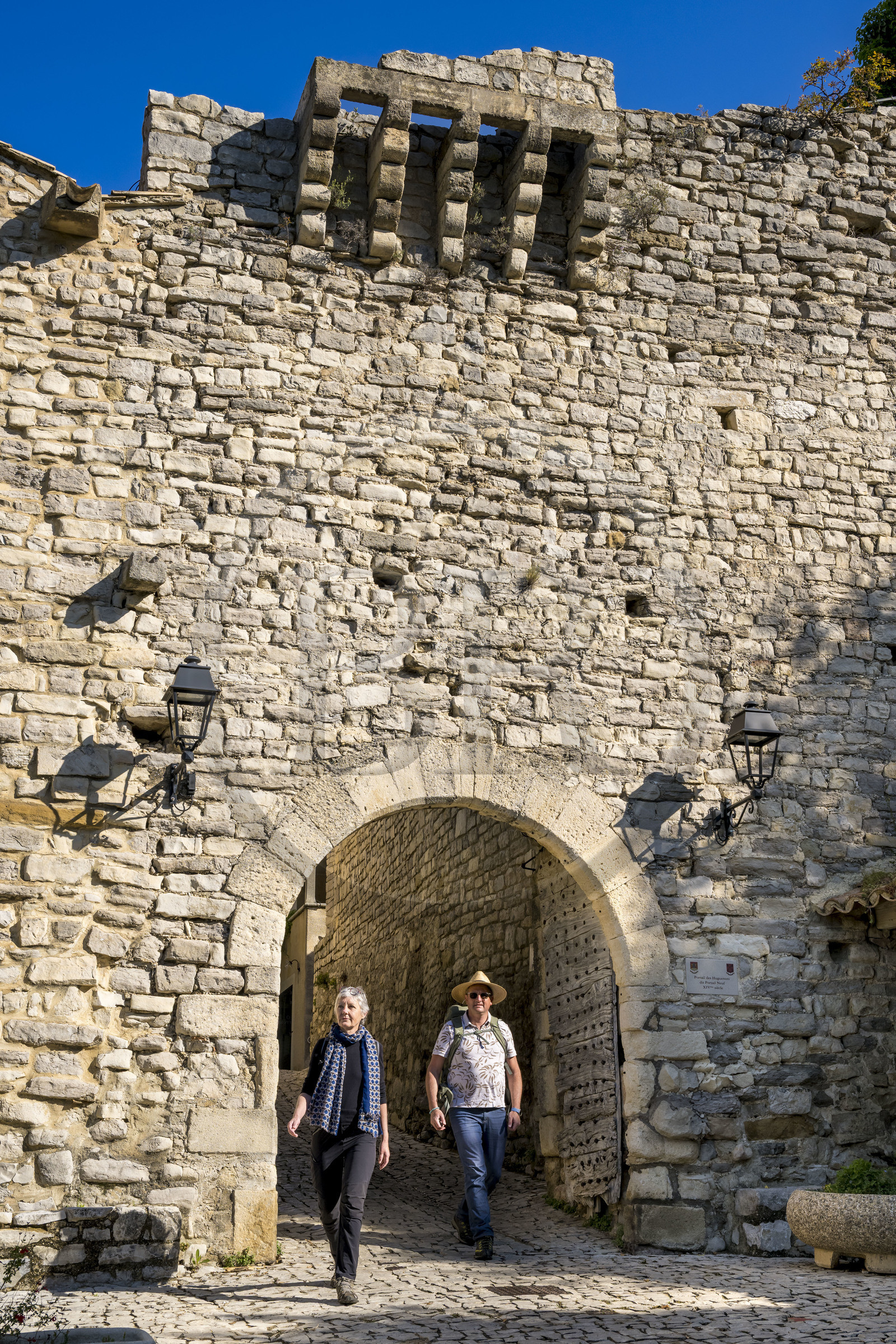France, Vaucluse, Dentelles de Montmirail mountains, the medieval village of Séguret, labelled Les Plus Beaux Villages de France (The Most Beautiful Villages of France), hikers leaving the village at Portail Neuf