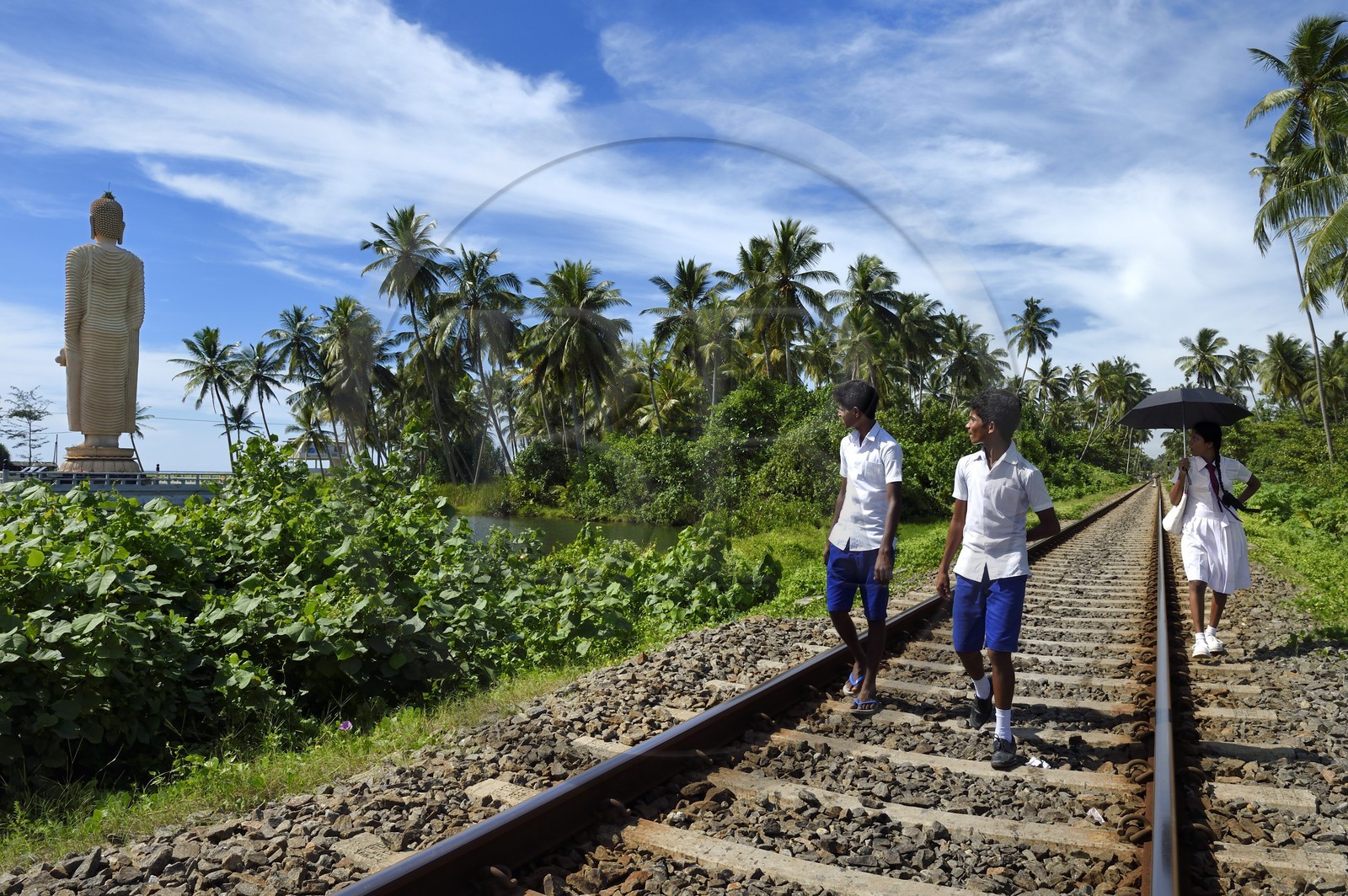 Sri Lanka, Southern Province, Galle district, Telwatta, school children walking on the railway from Colombo to Galle in front of the Peraliya Buddha in memory of the many victims of the crowded train swept away by the tsunami on December 26 2004