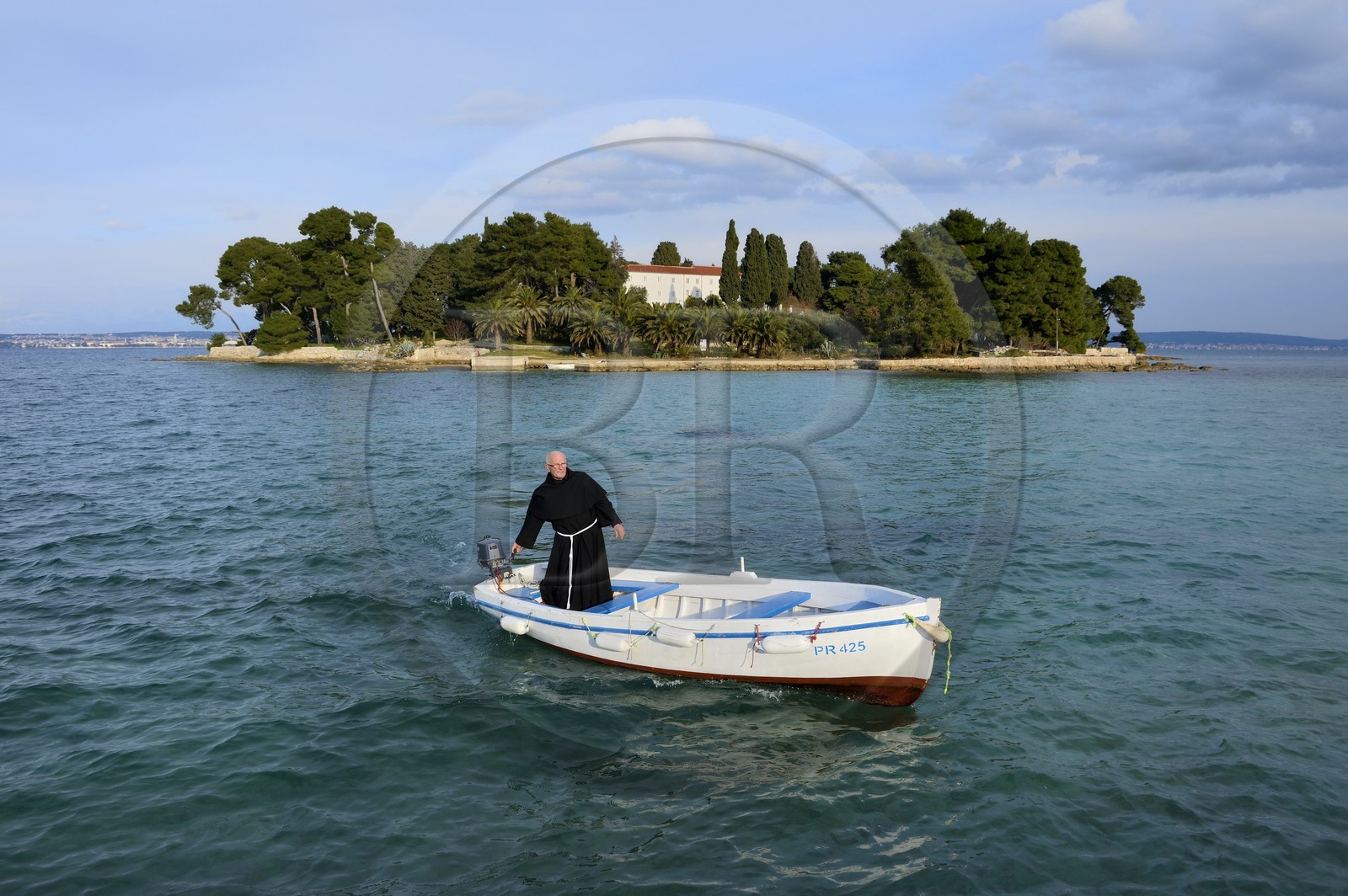 Croatia, Dalmatia, Dalmatian Coast, Ugljan Island, Preko, Franciscan friar Bozo Susic leaving the Franciscan Monastery of the Galovac island on his boat