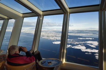 Groenland, cote Nord-Ouest, Smith sound au nord de la baie de Baffin, le bateau de croisière MS Fram de la compagnie Hurtigruten, passager observant la banquise depuis la salle panoramique
