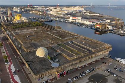 France, Loire-Atlantique (44), Saint-Nazaire, les anciennes bases sous-marines allemandes construites lors de la dernière guerre mondiale bordent le bassin à flot du port de Saint-Nazaire, en arrière plan à gauche le bassin de Penhoët et à droite le pont de Saint-Nazaire (vue aérienne)
