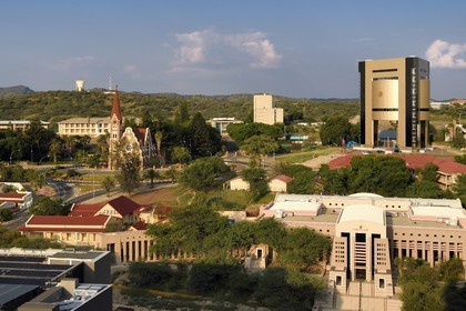 Namibia, Khomas region, Windhoek, Christ Church (or Christuskirche), Lutheran church designed by architect Gottlieb Redecker, the Independence Memorial Museum built by North Korea and the Supreme Court in the foreground