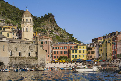 Italy, Liguria, Cinque Terre National Park listed as World Heritage by UNESCO, village of Vernazza, the parish church of Saint Margaret of Antioch (Santa Margherita) flanked by a high octagonal bell tower and the beach in the port on the right