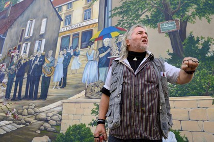 France, Moselle, Fensch Valley, the painter Greg Gawra Gawra in front one of his works on the wall of the Nilvange post office