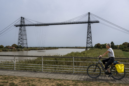 France, Charente Maritime, Rochefort, the Rochefort (or Martrou) transporter bridge built by Ferdinand Arnodin in 1900, cyclist along the cycle route