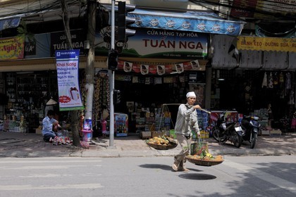 Vietnam, Hanoï, vieille ville, marchande de fruits (ananas) avec sa palanche