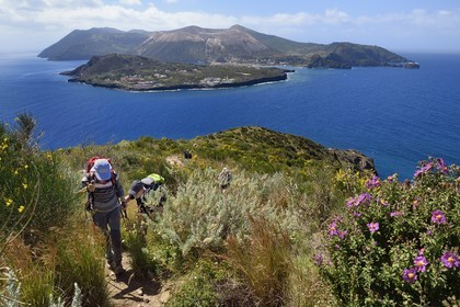Italy, Sicily, Aeolian Islands, listed as World Heritage by UNESCO, Lipari Island, hikers on the coastal path and Vulcano Island in the background