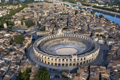 France, Bouches du Rhone, Arles, the Arena, a Roman amphitheater built around 80-90 AD, and the ancient theatre from the 1st century BC on the left, listed as World heritage by UNESCO, in the heart of the old town and the Rhone river in the background (aerial view)
