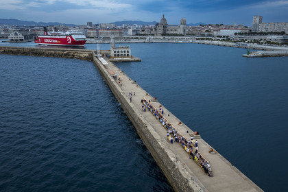 France, Bouches-du-Rhône (13), Marseille, Zone Euroméditerranée, grand port maritime de Marseille (GPMM), la digue du large, convives attablés à une grand table de banquet dressée par le chef Emmanuel Perrodin dans le cadre des Diners Insolites, un ferry de Corsica Linea quitte le port (vue aérienne)