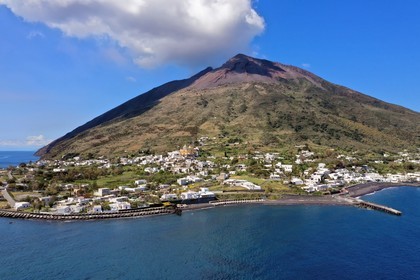 Italie, Sicile, iles Eoliennes, classées Patrimoine Mondial de l'UNESCO, ile de Stromboli, le village dominé par le volcan actif du Stromboli en arrière plan (vue aérienne)