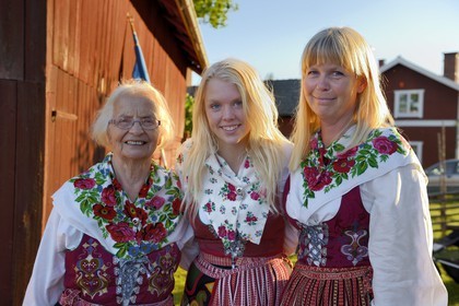 Sweden, Dalarna County, Leksand area, Midsummer celebrations in the tiny hamlet of Hjulbäck, three women in traditional costumes, grandmother, mother and daughter