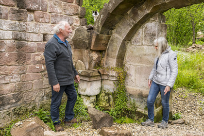 France, Bas Rhin, Parc regional des Vosges du nord (Northern Vosges Regional Natural Park), Eschbourg, ruins of Graufthal Abbey, remains of a 12th century vaulted room, the former village teacher Annette Oster with Marc Burckhart, also the former village teacher and president of the association for the enhancement of the Graufthal site