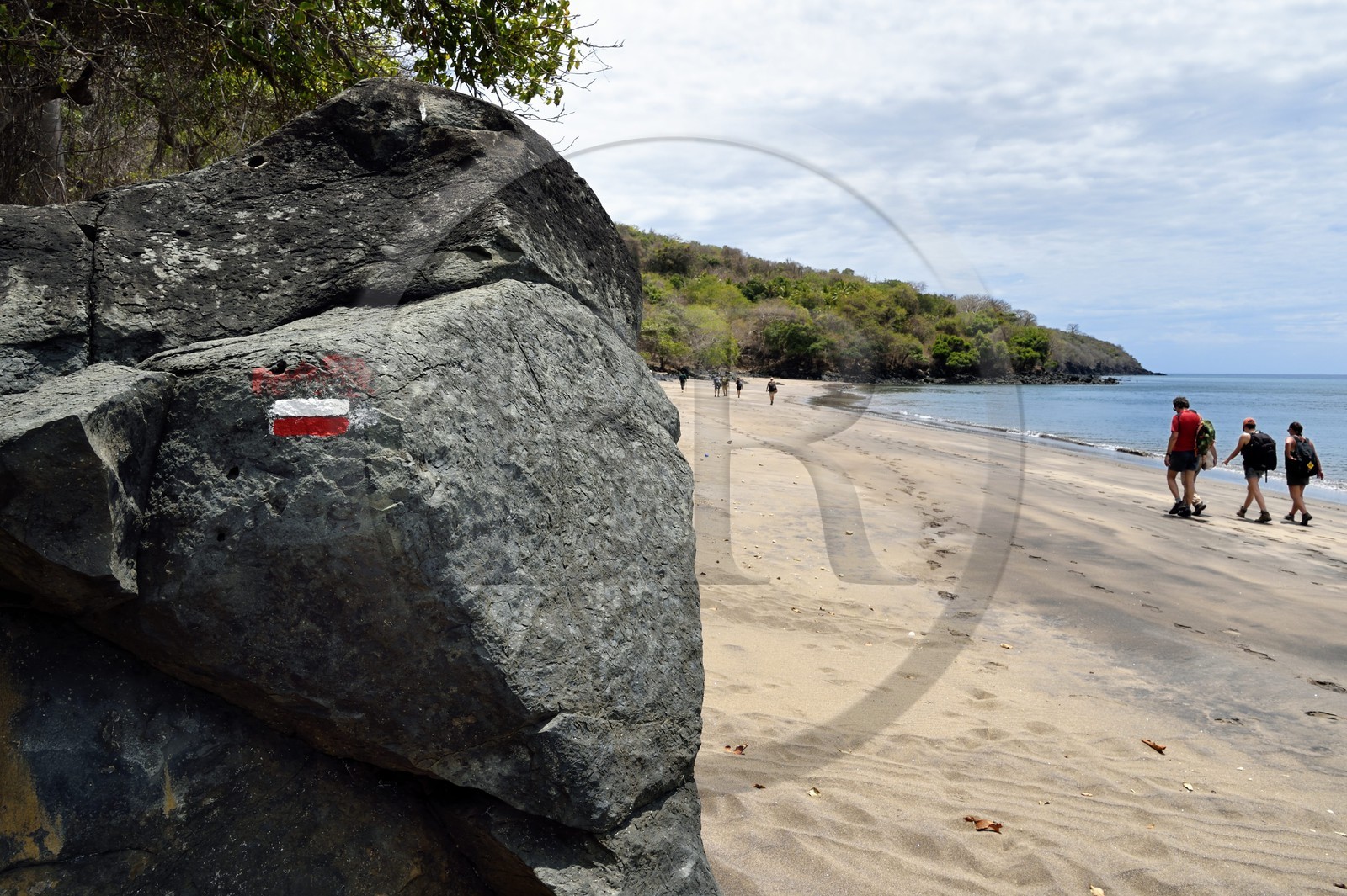 France, Ile de Mayotte, Grande-Terre, M'Tsamoudou, plage de Saziley, randonneurs marchant sur la plage sur le sentier de grande randonnée faisant le tour de l'ile, marque du sentier de randonnée du GR