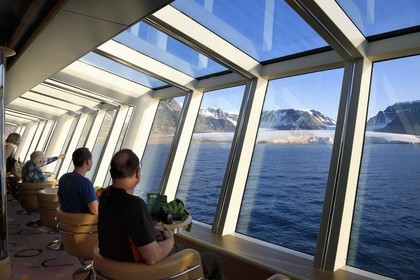 Groenland, cote Nord-Ouest, Murchison sund au nord de la baie de Baffin, le bateau de croisière MS Fram de la compagnie Hurtigruten, passager observant le glacier Kissel sur l'Ile de Kiatak (Northumberland Island) depuis la salle panoramique