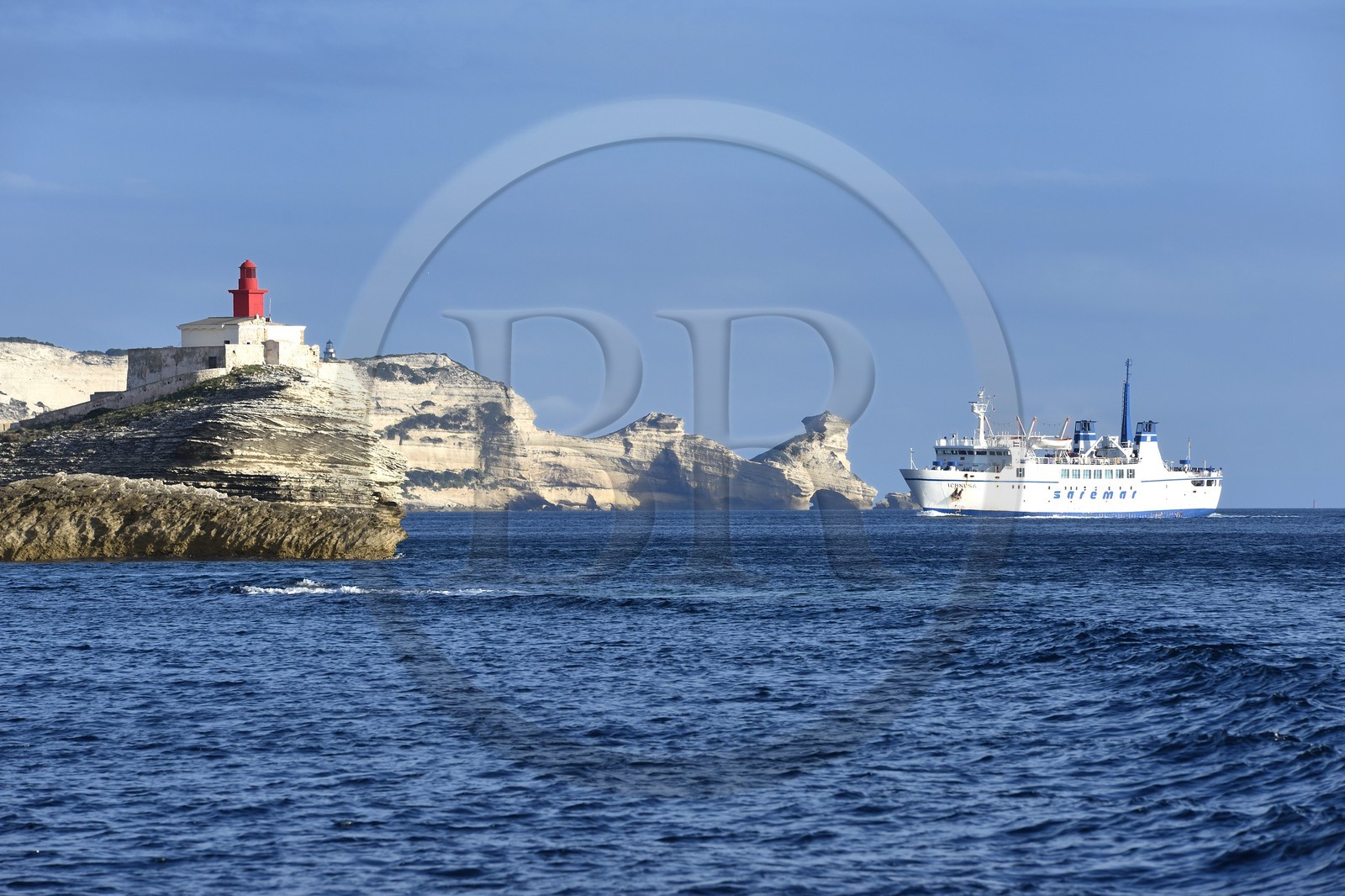 France, Corse du Sud, Bonifacio, connecting ferry to Sardinia arrival towards the limestone cliffs and the lighthouse at the entrance of the cove