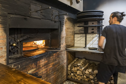 France, Alpes-Maritimes, Nice, listed as World Heritage by UNESCO, Old Nice, Antoine at the production of socca at Chez Theresa in the rue Droite, galette made from chickpea flour and a specialty of Nice
