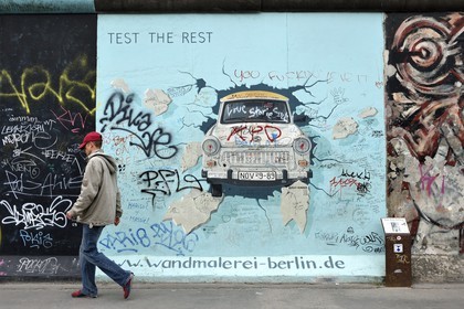 Germany, Berlin, Friedrichshain-Kreuzberg, East Side Gallery, The Wall, work by Birgit Kinder dating from the 1990's, renovated in 2009, representing a Trabant arriving in East Berlin, entitled Test the Best