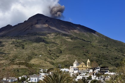 Italie, Sicile, iles Eoliennes, classées Patrimoine Mondial de l'UNESCO, ile de Stromboli, une des multiples et régiulières éruptions du volcan Stromboli qui culmine à 924m, Chiesa di San Vincenzo ( église Saint Vincent) dans le village de Stromboli au premier plan