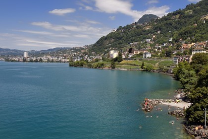 Switzerland, Canton of Vaud, Veytaux, the small beach at the foot of the Chillon castle on the shores of Lake Geneva (Lac Leman) and Montreux in the background