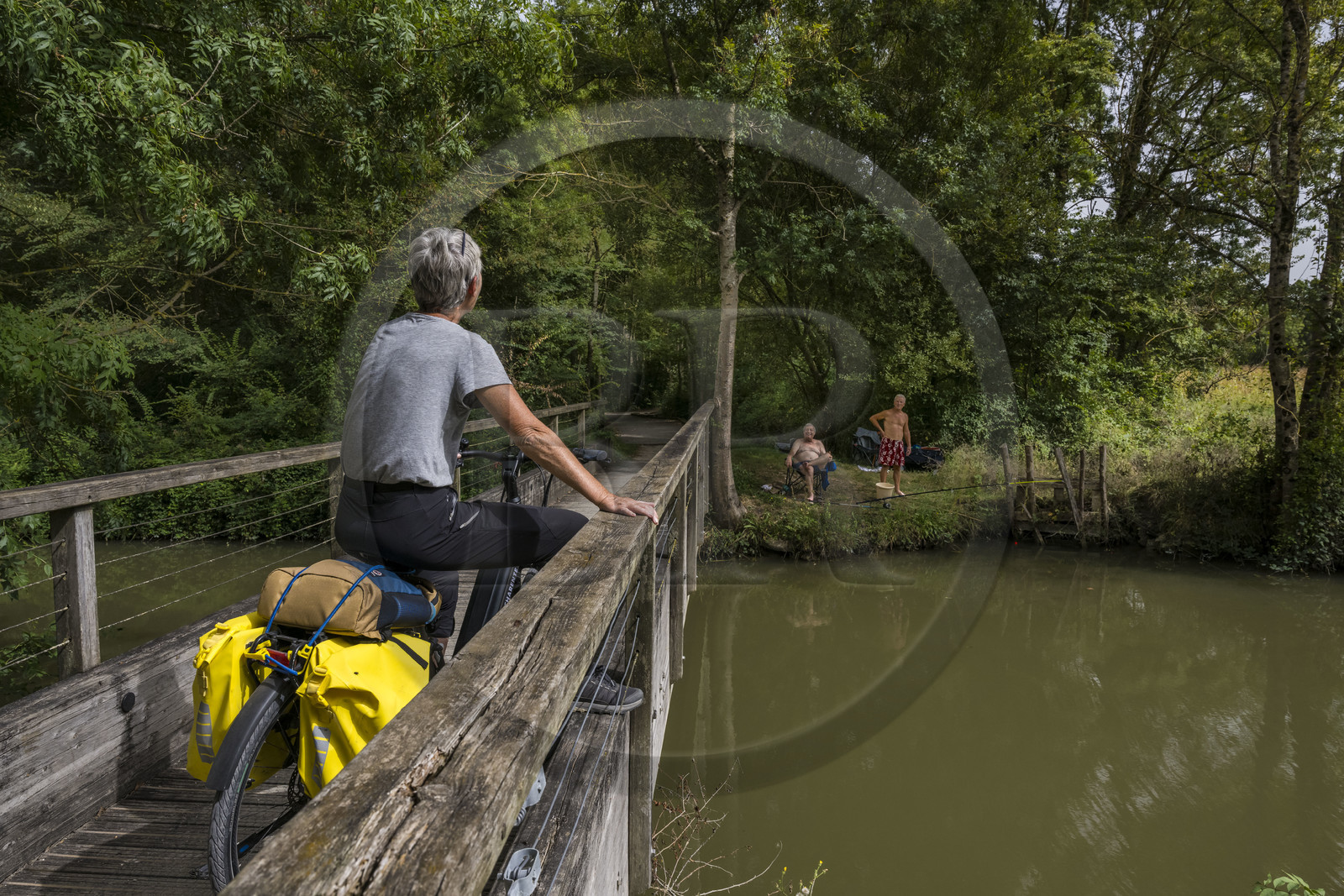 France, Charente-Maritime (17), Saint-Agnan, cycliste sur la véloroute en direction de l'abbaye de Trizay, rencontre avec des pêcheurs en bordure du petit canal de Pont-l'Abbé dans la vallée de l’Arnoult
