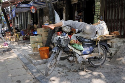 Vietnam, Hanoï, quartier des 36 rues dans la vieille ville, repos d'un livreur sur sa moto