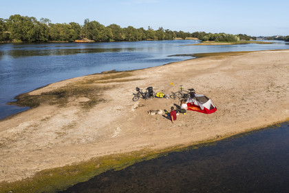 France, Maine-et-Loire, Loire valley listed as World Heritage by UNESCO, cycling along the banks of the Loire, camping for the night on one of the sandbanks forming islands on the Loire, a gabarre (traditional flat-bottomed boat) in the background (aerial view)