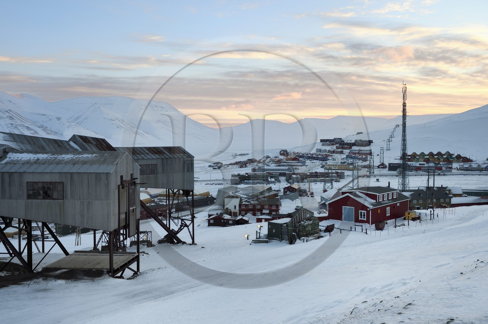 Norvège, Svalbard, Spitzberg, Longyearbyen, la ville et au premier plan le batiment central abandonné du téléphérique utilisé pour le transport des chariots de charbon des mines vers le port
