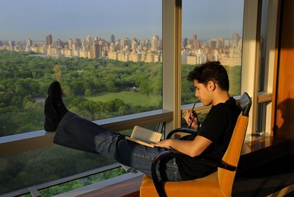United States, New York City, Manhattan, reading a book facing Central Park