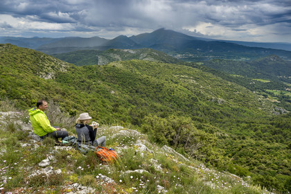 France, Vaucluse, Dentelles de Montmirail mountains, hikers taking a lunch break on the ridges of Saint-Amand on the GR 4, Mont Ventoux in the background
