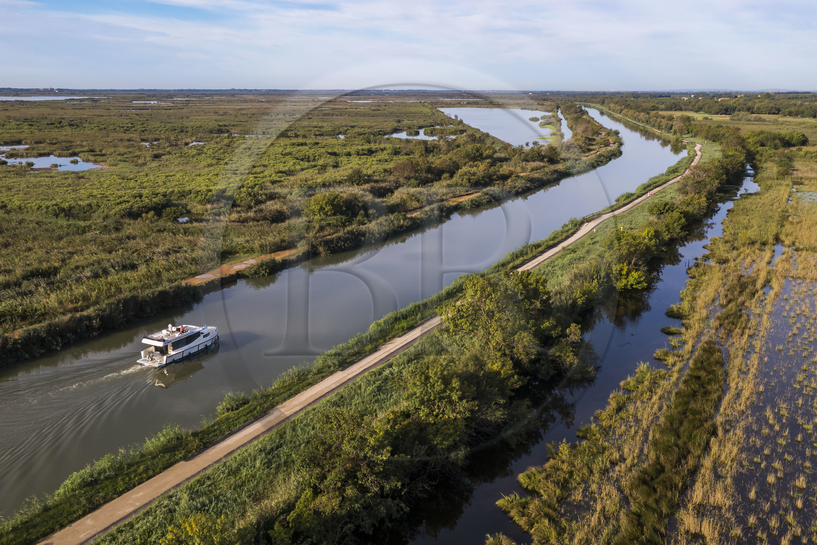 France, Gard (30), la Petite Camargue, navigation d'un bateau de plaisance Le Boat sur le canal du Rhône à Sète entre Gallician et Aigues-Mortes (vue aérienne) France, Gard, the Petite Camargue, navigation of a pleasure boat Le Boat on the Rhone to Sète Canal between Gallician and Aigues-Mortes (aerial view)