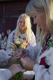 Sweden, Dalarna County, Leksand area, Midsummer celebrations in the tiny hamlet of Hjulbäck, woman in traditional costume, preparation of the maypole