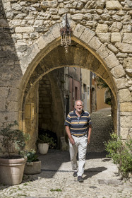 France, Drome, regional natural park of Baronnies provencales, Montbrun les Bains, labeled the Most Beautiful Villages of France, old gate of the ramparts at the entrance to the medieval village Place du Beffroi, Gérard Chappon, deputy mayor of the commune and amateur historian