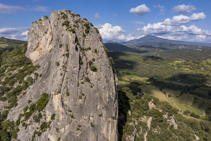 France, Vaucluse, Dentelles de Montmirail mountains, Lafare, limestone peak in the shape of a sugar loaf on one of the foothills of the Dentelles Sarrasines at the Col du Cayron and overlooking the Saint-Christophe waterfall on La Salette, the Saint-Christophe chapel on the right and the Mont Ventoux in the background (aerial view)