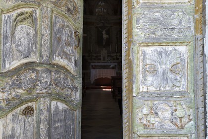France, Haute Corse, Castagniccia, village of Piazzole d'Orezza, Church of the Annunciation, the tradition reported that a repentant bandit carved on the door of the church several biblical scenes (the announcement to Mary, David and Goliath) and a beautiful scenery of vineyards and wheat