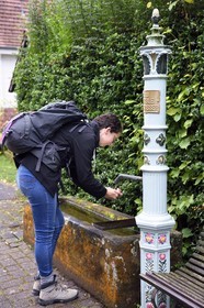 France, Bas Rhin, Northern Vosges Regional Natural Park, Niedersteinbach, hiker drinking at one of the many fountains of the village