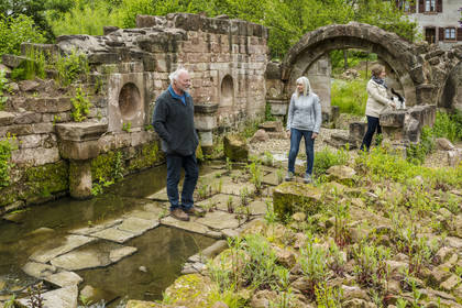 France, Bas Rhin, Parc regional des Vosges du nord (Northern Vosges Regional Natural Park), Eschbourg, ruins of Graufthal Abbey, remains of a 12th century vaulted room, the former village teacher Annette Oster with Marc Burckhart, also the former village teacher and president of the association for the enhancement of the Graufthal site