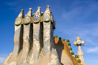 Spain, Catalonia, Barcelona, Eixample district, Passeig de Gracia, Casa Batllo by Catalan modernist architect Antoni Gaudi, UNESCO World Heritage site, chimneys, roof suggesting a dragon's spine and tower crowned with a ceramic spire surmounted by a typical Gaudi cross