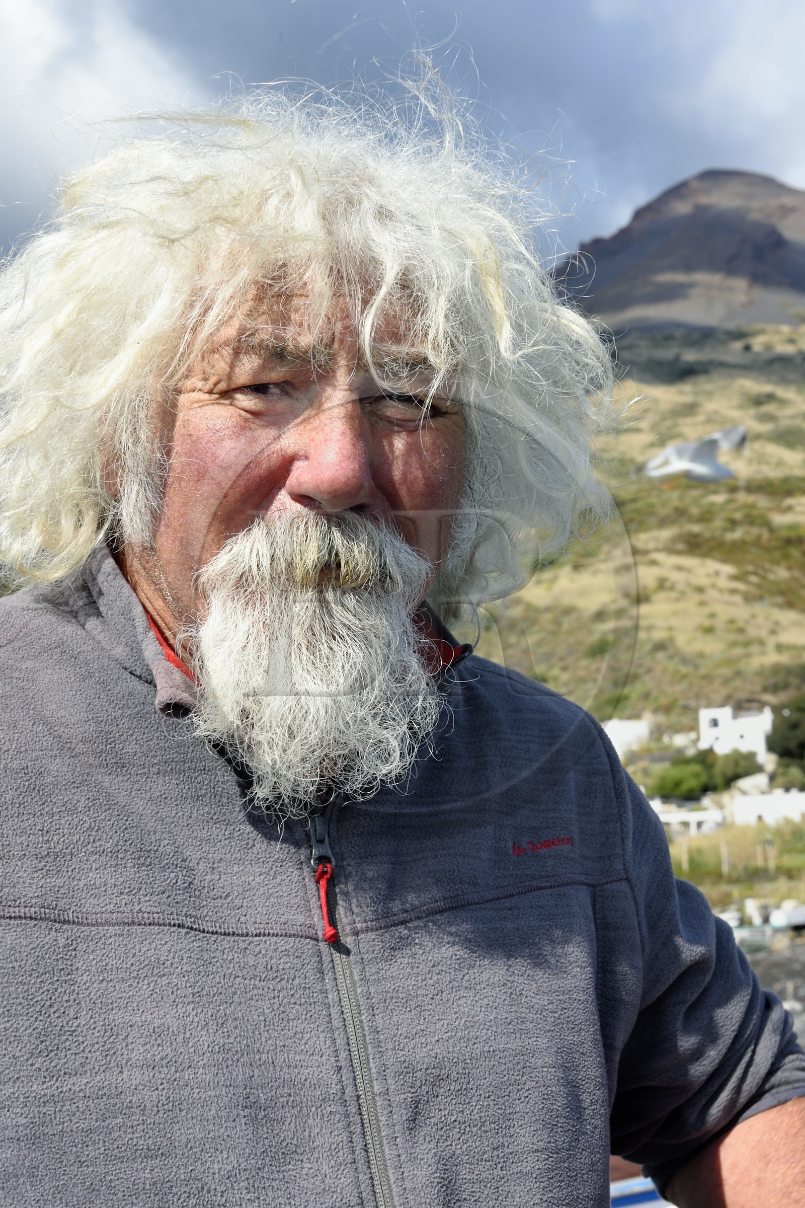 Italie, Sicile, iles Eoliennes, classées Patrimoine Mondial de l'UNESCO, ile de Stromboli, le pecheur Gaetano Cusolito sur la plage de Scari et le volcan du Stromboli en arrière plan