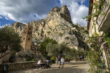 France, Alpes de Haute Provence, Parc Naturel Régional du Verdon, village of Moustiers Sainte Marie, labelled Les Plus Beaux Villages de France (The Most Beautiful Villages of France), the Notre-Dame-de-l'Assomption church with its 12th century bell tower and the Notre-Dame de Beauvoir chapel in the background in the cliff