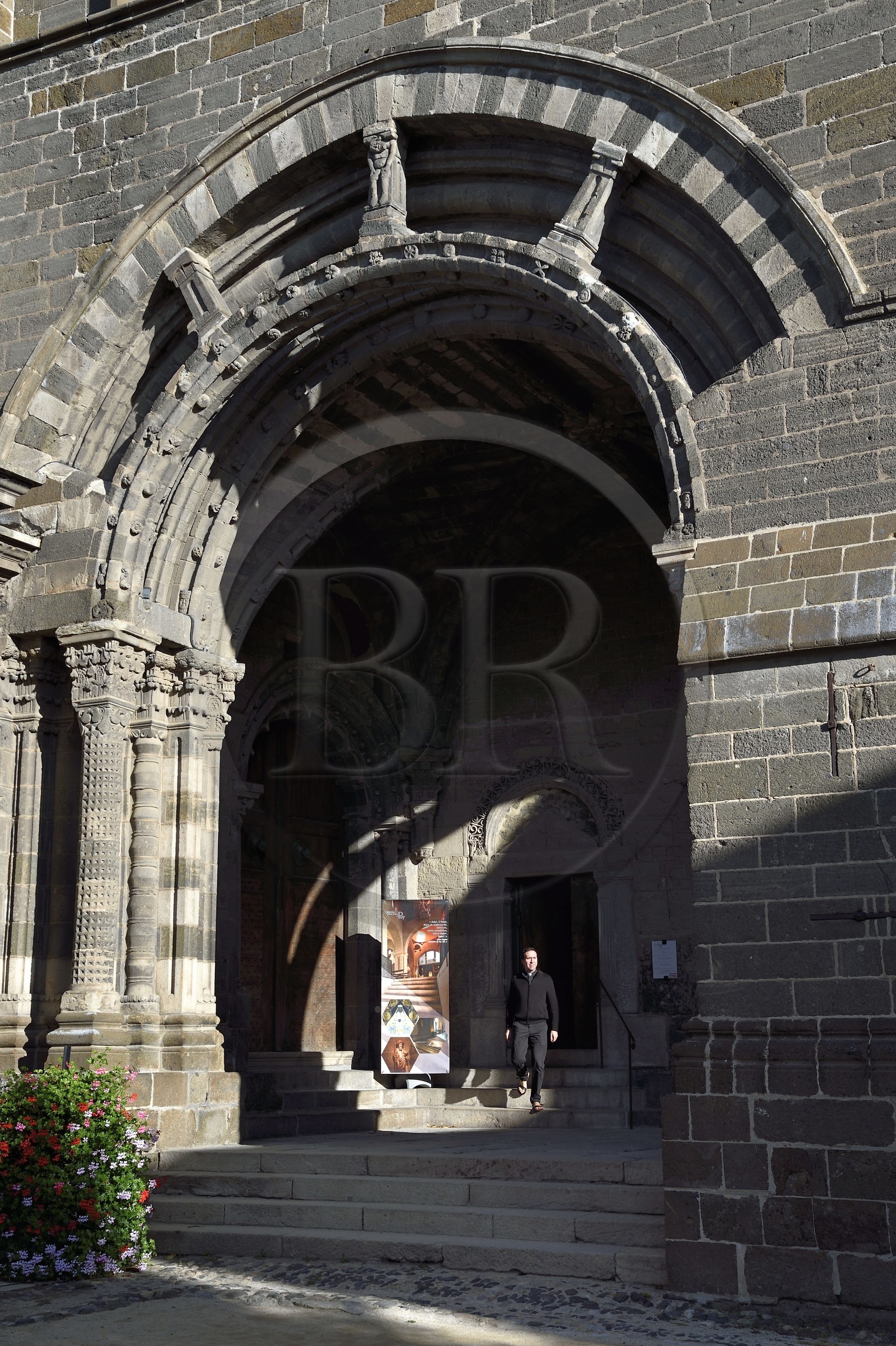 France, Haute-Loire (43), Le Puy-en-Velay, étape des chemins de Compostelle, la cathédrale Notre-Dame-de-l'Annonciation du XIIe siècle classée Patrimoine Mondial de l'UNESCO, l’abbé Nicolas Pourrat, chapelain de la cathédrale, sous le porche du For