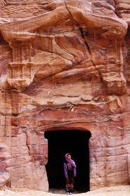 Jordan, Petra, a young Bedouin in front of tomb's frontage