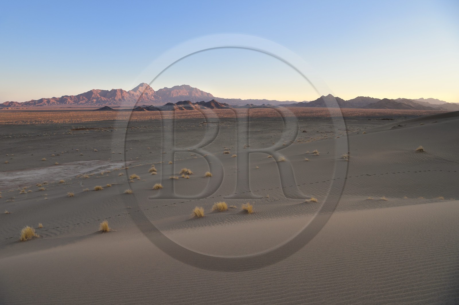Iran, Province de Yazd, désert du Dasht-e Kavir, Moghestan, le massif montagneux de Moghestan face aux dunes dont la plus haute atteint les 200 mètres