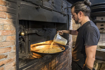 France, Alpes-Maritimes, Nice, listed as World Heritage by UNESCO, Old Nice, Antoine at the production of socca at Chez Theresa in the rue Droite, galette made from chickpea flour and a specialty of Nice