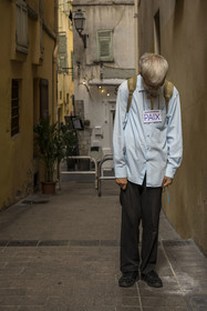 France, Alpes-Maritimes, Nice, listed as World Heritage by UNESCO, man carrying a cross and a Peace sign in a street in the Old Nice