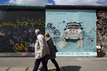 Germany, Berlin, Friedrichshain-Kreuzberg, East Side Gallery, The Wall, work by Birgit Kinder dating from the 1990's, renovated in 2009, representing a Trabant arriving in East Berlin, entitled Test the Best