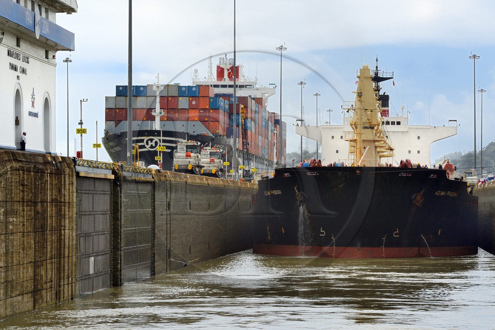 Panama, Canal de Panama, écluses de Miraflores, mules mécaniques ou locomotives électriques guidant un cargo Panamax entre les murs de l'écluse