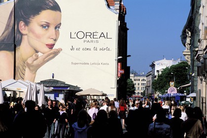 Latvia (Baltic States), Riga, pedestrian on the square being next to Kalku street, a promotional fresco with the French top model Laetitia Casta for L'Oreal