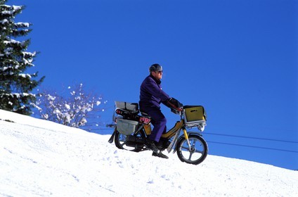 Switzerland, Bern Region (Bernese Oberland), Grindenwald, postman delivering on snow