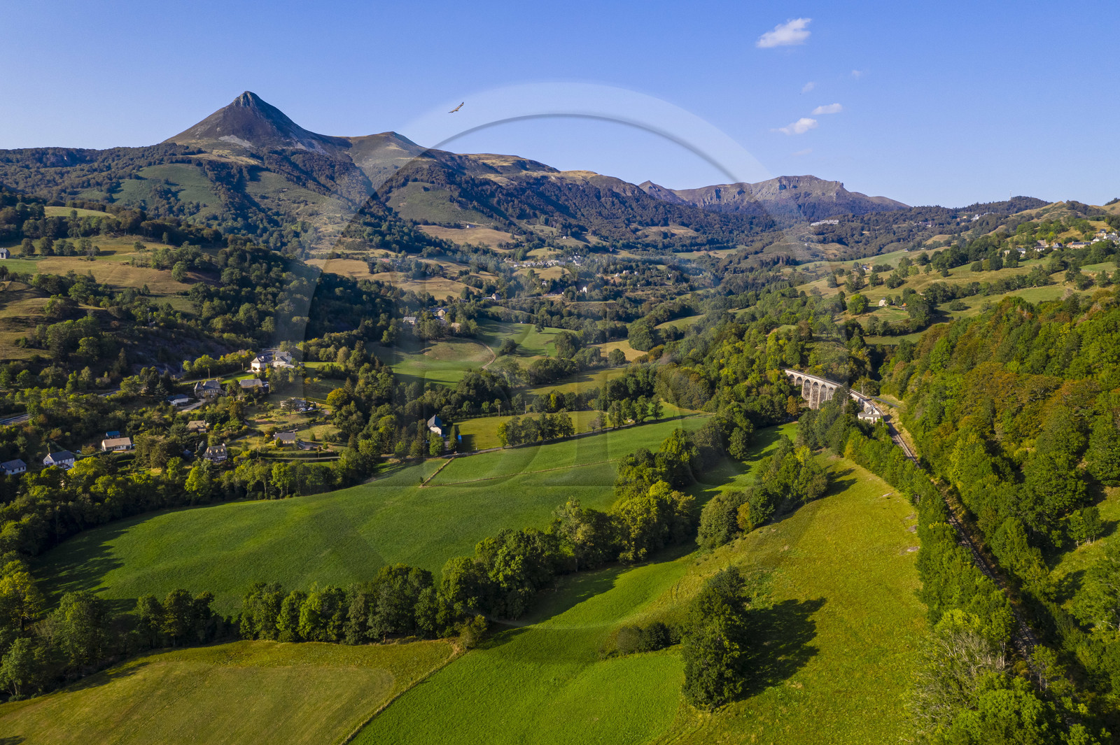 France, Cantal (15), Parc Naturel Régional des Volcans d'Auvergne, Saint-Jacques-des-Blats sur le chemin de Saint-Jacques de Compostelle par la Via Arverna, la vallée de la Cère, en arrière plan de gauche à droite le Puy Griou, le col de Rombière, le sommet du Téton de Venus et le Rocher du Bec de l'Aigle (vue aérienne)