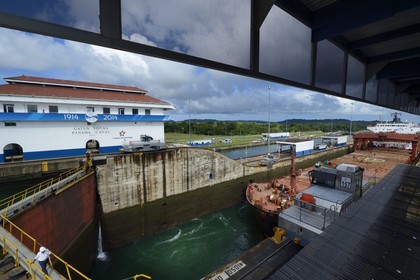 Panama, Colon province, Panama Canal, Gatun locks, mechanical mules or electric locomotives guiding a Panamax cargo between the lock walls